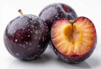 Buah plum ungu segar dibelah dan utuh, dengan selai rumahan di meja rustik