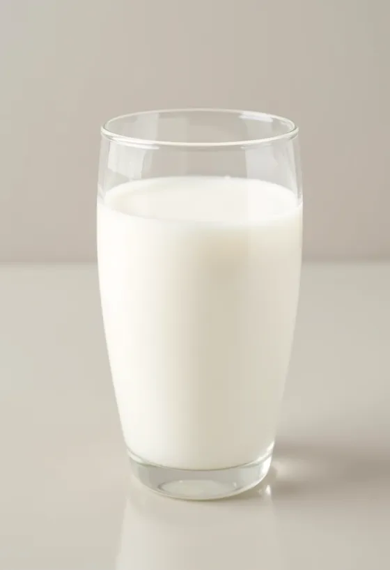 Gelas dan botol susu segar di meja dapur yang terang, tanpa elemen hewani