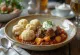 Pörkölt dengan dumpling keju cottage dan krim asam disajikan