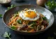 Japchae disajikan, dengan mie ubi jalar, daging sapi, dan sayuran