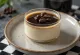 Panna cotta kopi dihiasi dengan bubuk kakao dan krim kocok