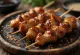 Hatsu yakitori jantung ayam di tusuk sate, disajikan dengan biji wijen dan bawang hijau segar
