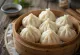 Baozi kukus Cina disajikan di pengukus bambu, dengan adonan tertutup rapat