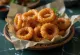 Cincin bawang renyah BBQ dalam piring saji