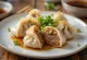 Jiaozi bebek Peking Cina rebus, di piring putih, isian bebek terlihat