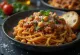 Pasta bolognese vegan dengan kacang arab disajikan di piring putih