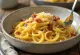 Pasta carbonara creamy dengan taburan lada hitam dan daging asap