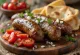 Cevapi dengan tomat, baru dipanggang dan berwarna cokelat keemasan, disajikan di atas roti pita
