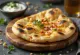 Chilis naan segar, dihiasi potongan cabai, disajikan hangat