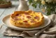 Quiche keju asap dan daging sapi asap diiris dalam penyajian pedesaan