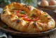 Khachapuri dengan Tomat, roti pipih keju cokelat keemasan segar dengan irisan tomat
